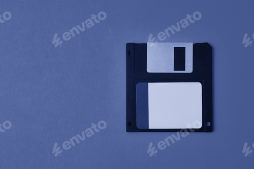 Preview: Black floppy diskette on blue background. Vintage computer diskette, closeup