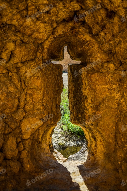 Preview: a cross is embedded into a hole in the side of some rocks