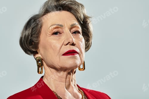 Preview: A stylish woman in her 60s confidently showcases elegant attire with a poised expression.