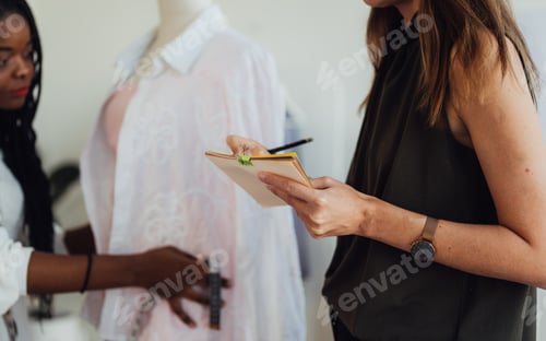 Preview: Happy Couple of fashion designer working together in workshop studio
