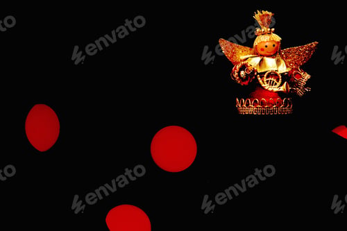 Preview: Closeup of a small cute Christmas angel ornament in front of a background with bokeh lights