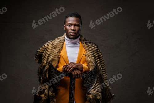 Preview: Stylishly dressed dark-skinned man wearing a yellow jacket and wild animal fur