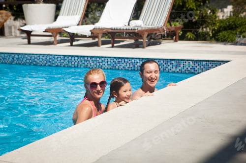 Preview: Young family in swimming pool together