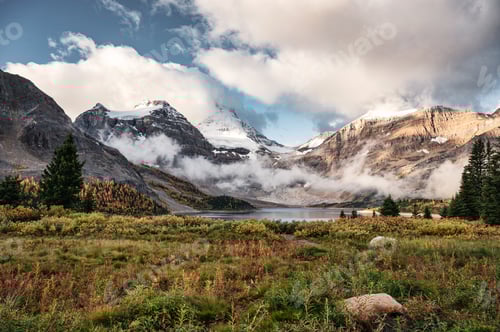 Preview: Mount Assiniboine with foggy and cloudy on Lake Magog in autumn forest at provincial park
