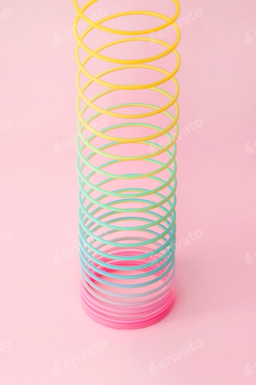 Preview: Rainbow plastic spring toy on pink background