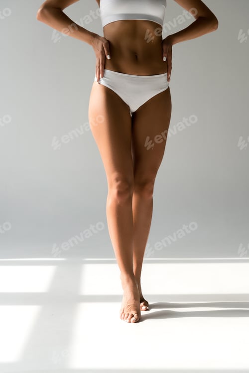 Preview: cropped view of slim woman in underwear posing with hands on hips on tiptoe