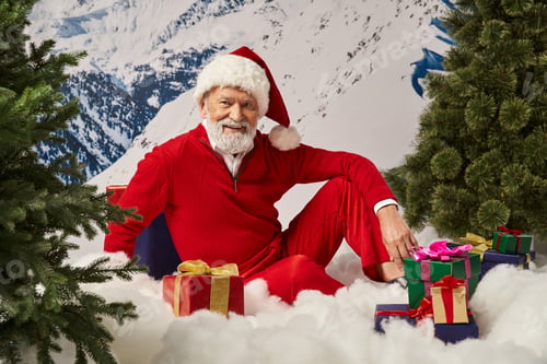 Preview: happy Santa sitting on snow surrounded by many presents and smiling at camera, Merry Christmas