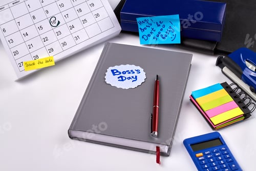 Preview: 16 day of october marked as boss day. Book with pen and calculator.