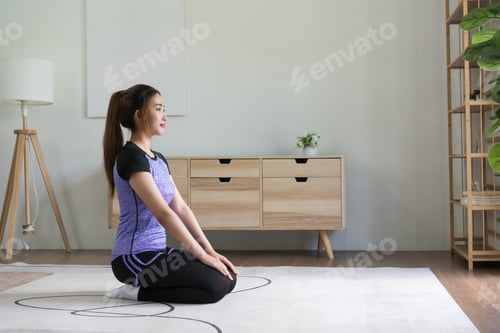 Preview: Young asian woman doing yoga exercise vajrasana diamond pose for workout healthy lifestyle at home