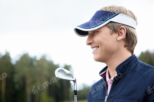 Smiling Man in Visor Holding Golf Club