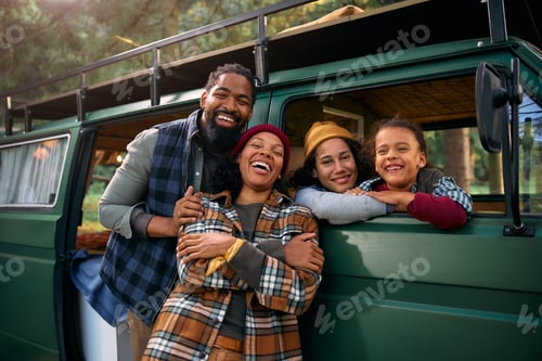 Preview: Cheerful black family enjoying in camping in the woods.