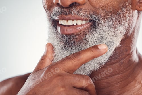 Preview: Hand, beard and smile with a senior black man grooming in studio on a gray background for beauty or