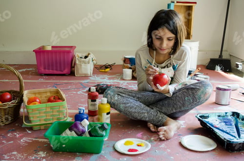 Preview: Girl sitting cross-legged painting fruit