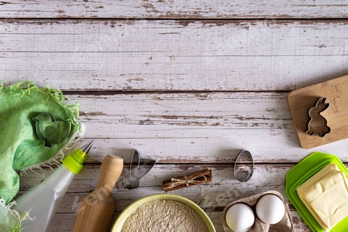 Preview: Flat lay on Easter cookie baking ingredients on light wooden background and baking molds