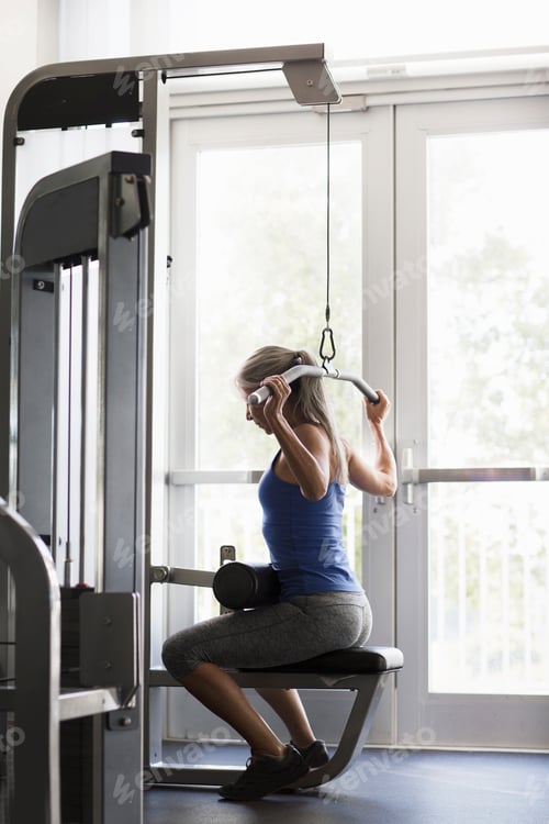 Preview: Woman exercising on a cable machine at the gym