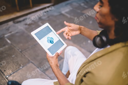 Preview: Crop man browsing tablet on street