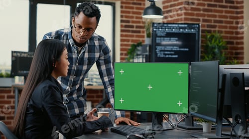 Preview: Mixed team of programmers analyzing source code looking at green screen chroma key mockup