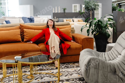 Preview: Woman relaxing on comfortable sofa in furniture store showroom