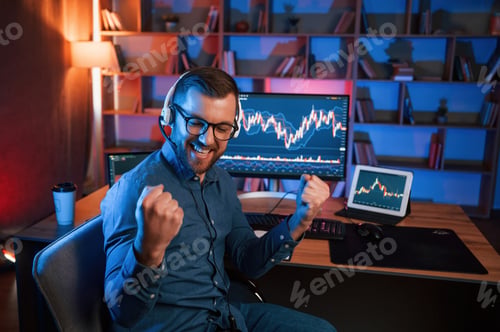 Preview: Happy stock trader is working by pc indoors and celebrating success. Conception of exchange