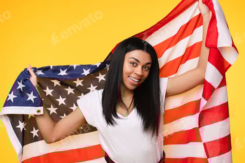Preview: 4th of July Independence Day of USA. Happy afro-american girl with American flag yellow background