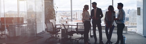 Preview: Business team standing against panoramic windows in modern office