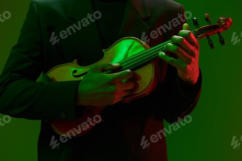 Preview: elegant man in suit playing violin with dramatic green and red lighting in background
