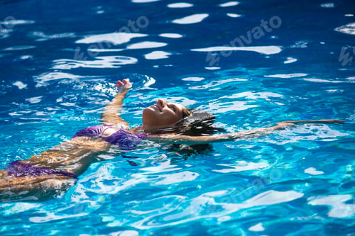 Preview: Woman doing backstroke in swimming pool