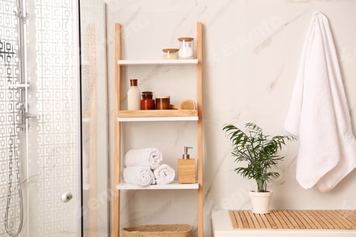 Preview: Soft towels and different toiletries on decorative ladder in bathroom. Interior design