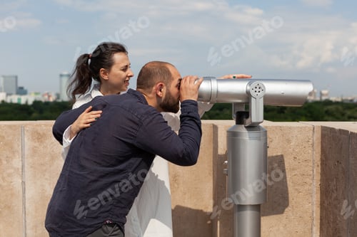 Preview: Happy lovers enjoying summer spending time on building tower