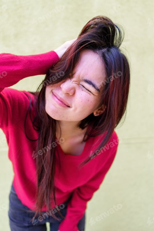 Preview: Confused woman wearing red sweater and blue jeans, scratching head with closed eyes