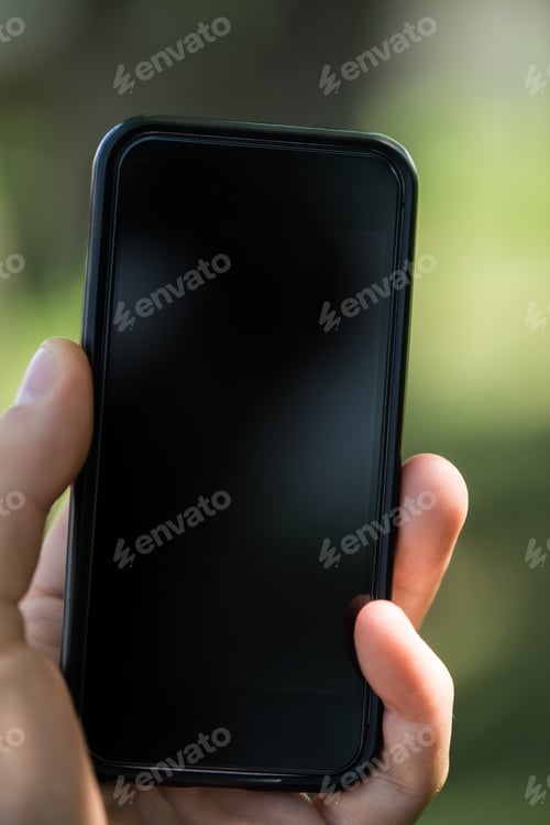 Preview: partial view of man holding smartphone with blank screen in hand