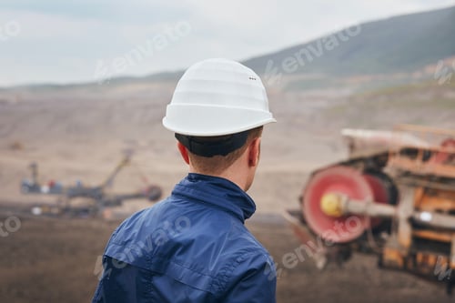 Preview: Coal mining in surface mine. Miner looking on the huge excavator.