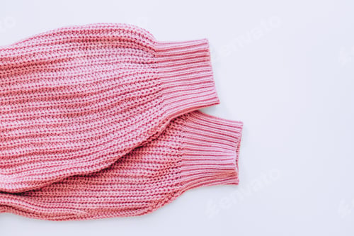 Preview: Pink sweater sleeves on white background with copy space
