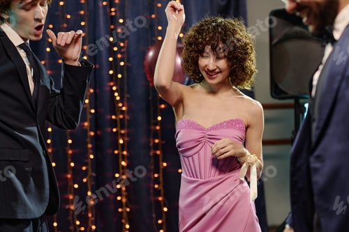 Preview: Caucasian Teen Girl Dancing with Teen Boys at Festive Indoor Party Event