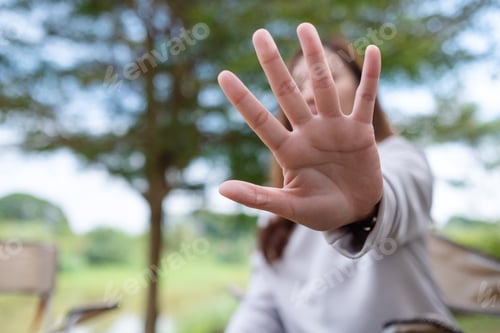 Preview: A young asian woman outstretched hand and showing stop hand sign