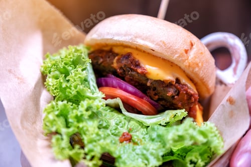 Preview: Closeup image of a beef cheeseburger in restaurant
