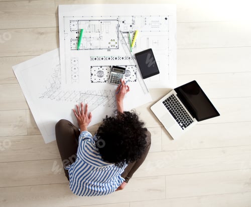Preview: Female architect studying plans in office, she drawing with pencil and ruler.
