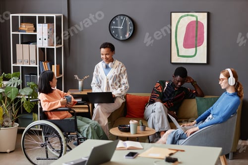 Preview: Diverse group of young people with person with disability in business meeting