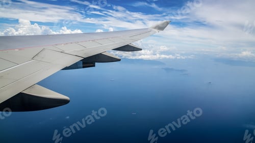 Preview: Aerial view of blue ocean from an airplane window. Traveling by air.
