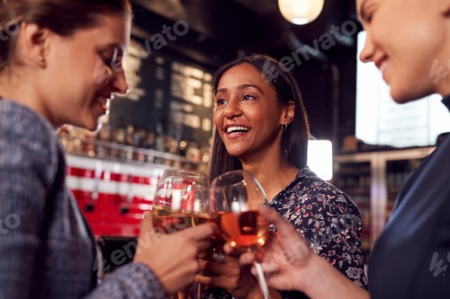 Preview: Three Women Making A Toast As They Meet For Drinks And Socialize In Bar After Work