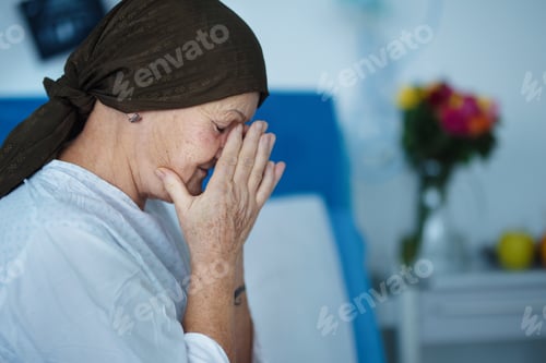 Preview: Senior woman sitting in hospital room after chemotherapy.