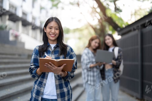 Preview: young happy attractive asian student smiling and looking at camera with friends on outdoor