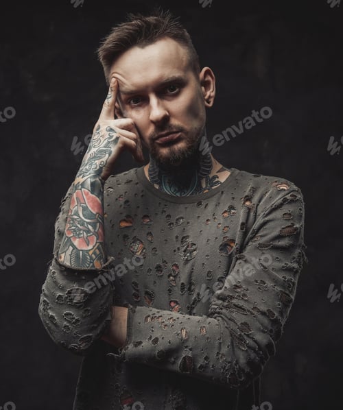 Preview: Hipster person poses in dark background with finger to his head