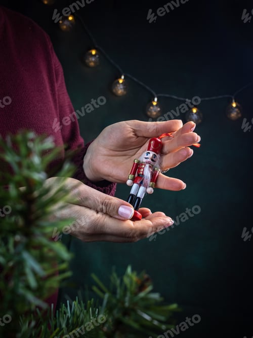 Preview: Christmas decoration wooden soldier in the hands, dark background with Christmas lights