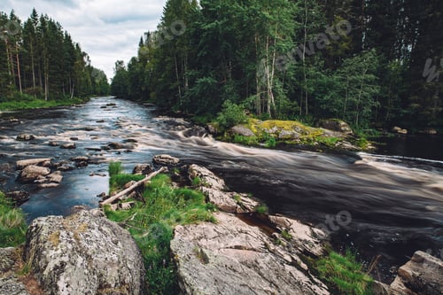 Preview: Mountain fast river stream of water in the rocks with green forest in Finland