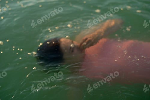 Preview: Woman floating in green water, partially submerged