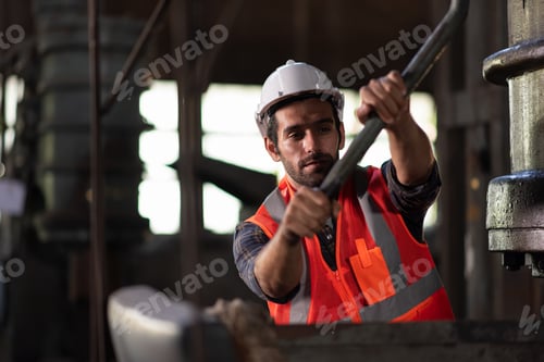 Preview: Worker at machine in factory, Metal industry worker at factory.