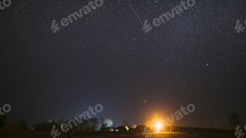 Preview: Real Night Sky Stars Above Old Village. Natural Starry Sky Above Rural Countryside Landscape In