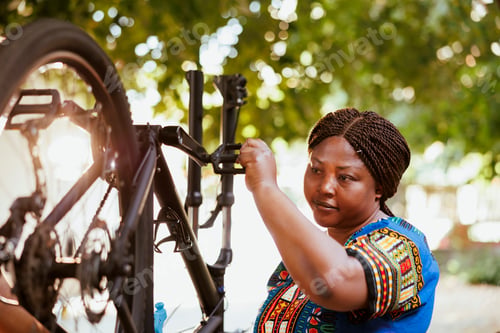 Preview: Young woman repairing bicycle wheel