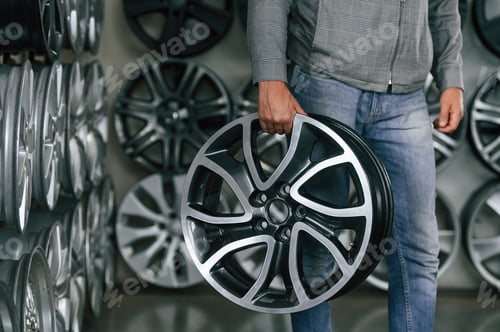 Preview: Disk in hands. Man is in the tire fitting car service